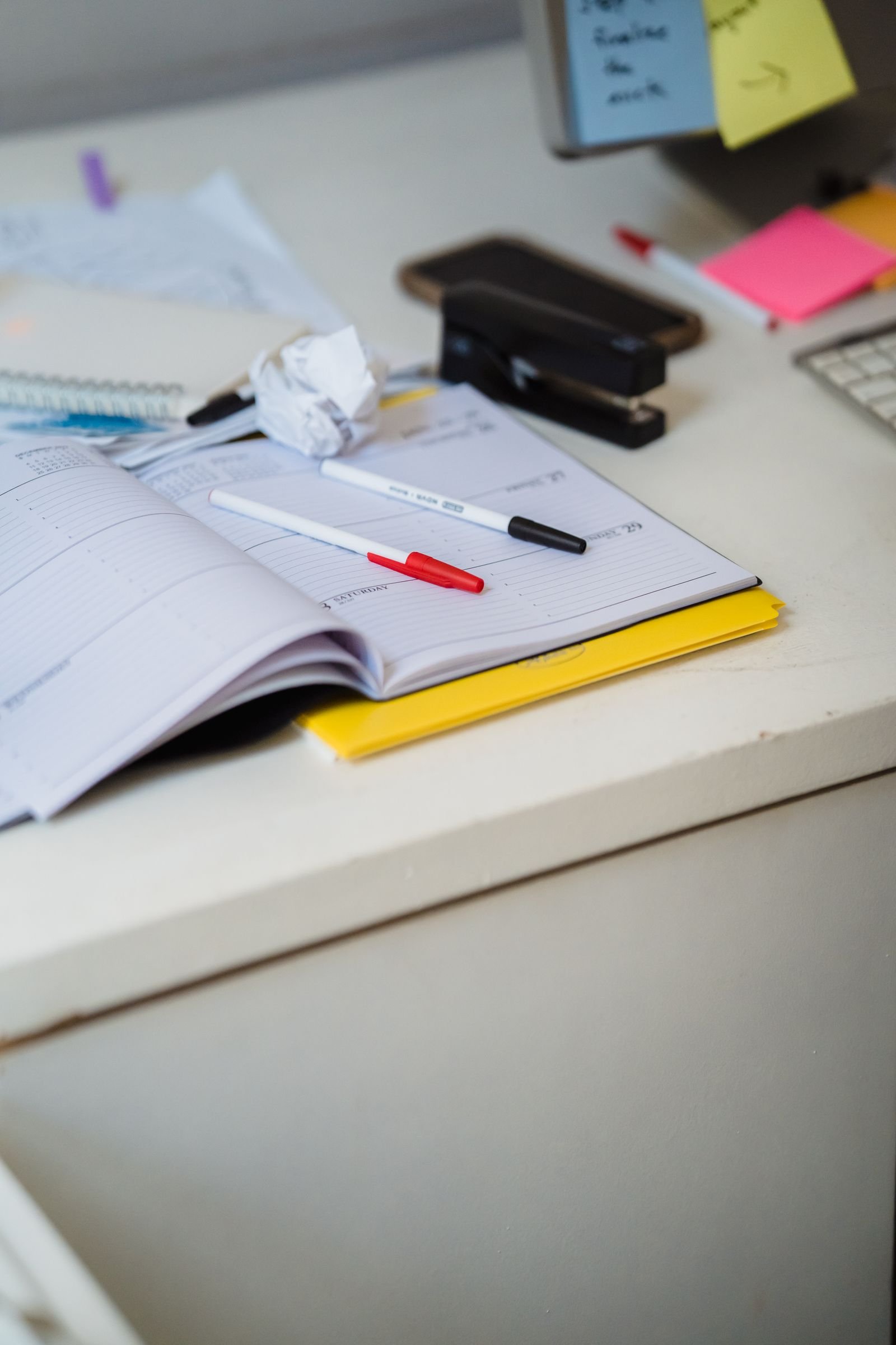 Planner, pens and office supplies on a desk used for planning a content calendar